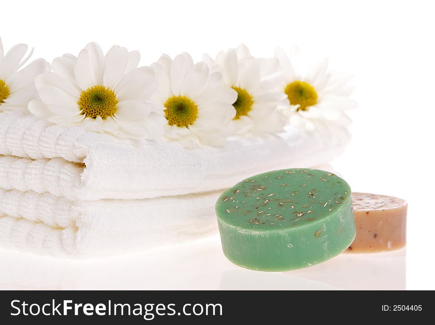 Towels, soap bars, and daisies on white isolated. Towels, soap bars, and daisies on white isolated