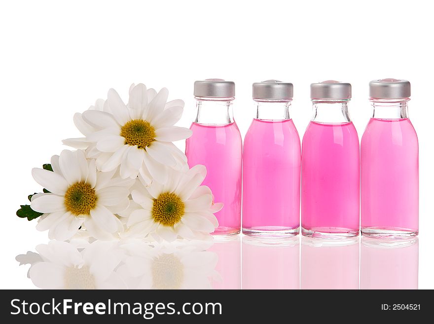 Spa bottles and daisies isolated on white background. Spa bottles and daisies isolated on white background