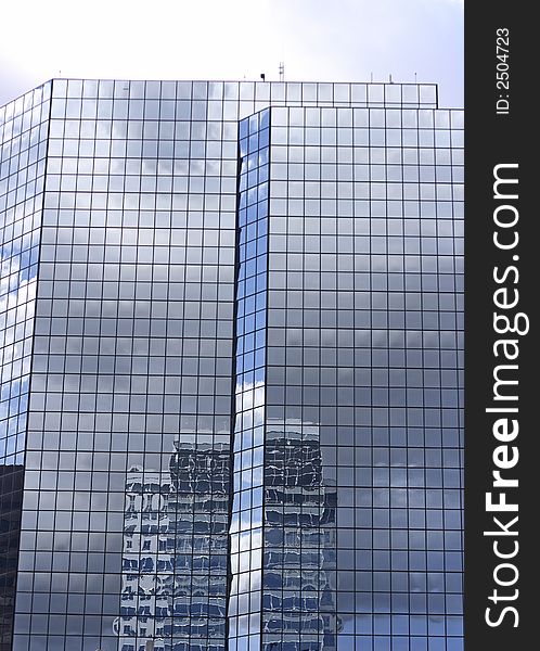 A modern office building in a sprawling urban area with reflection. A modern office building in a sprawling urban area with reflection