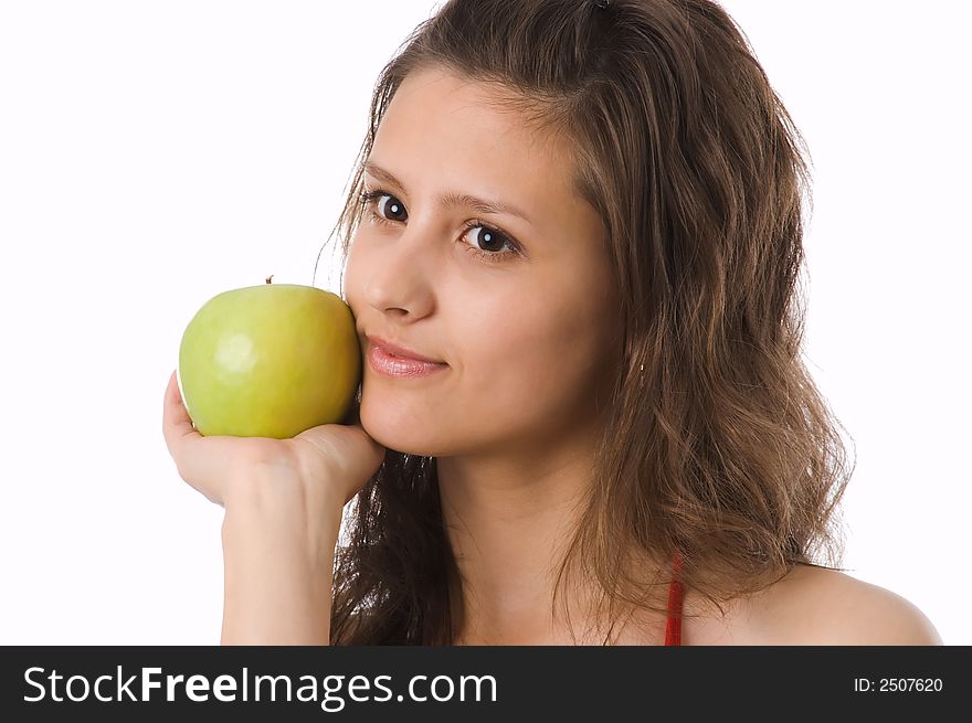 The brown-eyed girl holds a green apple in hands. The brown-eyed girl holds a green apple in hands