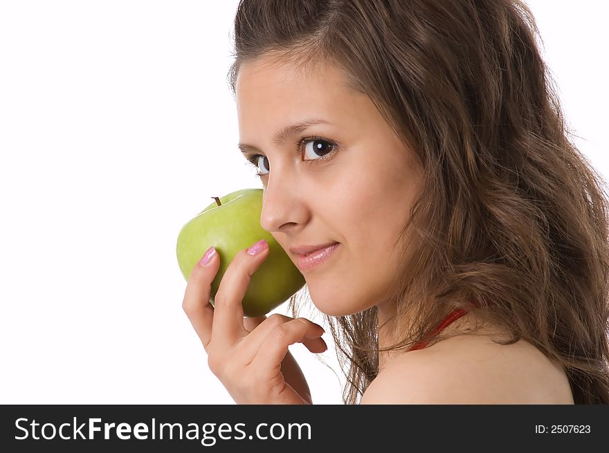 The brown-eyed girl holds a green apple in hands. The brown-eyed girl holds a green apple in hands