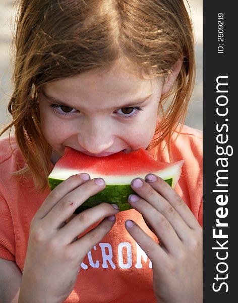 A girl is eating watermelon