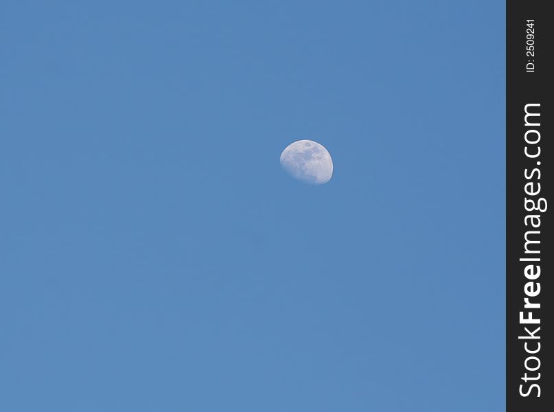 Moon against blue evening sky background. Moon against blue evening sky background