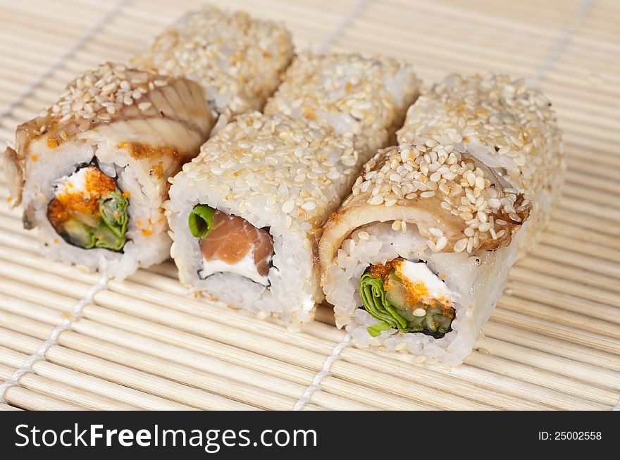 Photos of Japanese Sushi rolls with salmon on bamboo mat