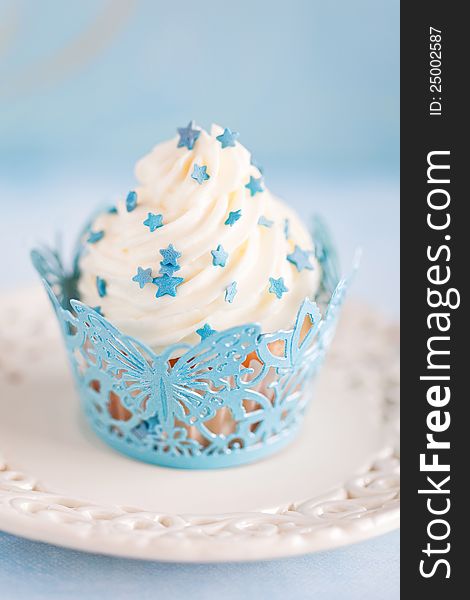 Cupcake with cream and blue decor, selective focus