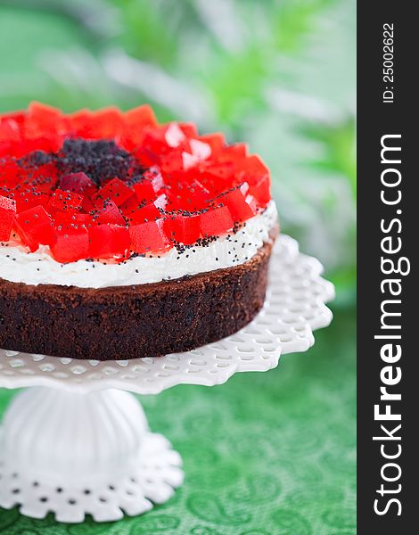 Poppy seeds and chocolate cake with red jelly, selective focus