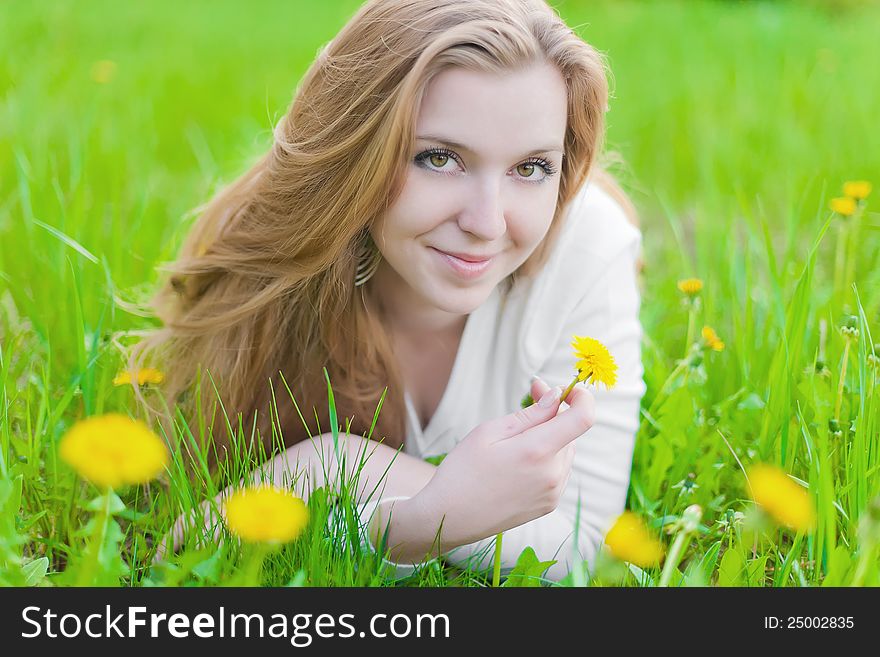 Girl on yellow dandelion on green field. Girl on yellow dandelion on green field
