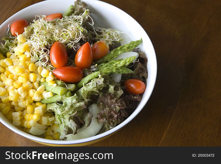 Mixed salad bowl on wood background