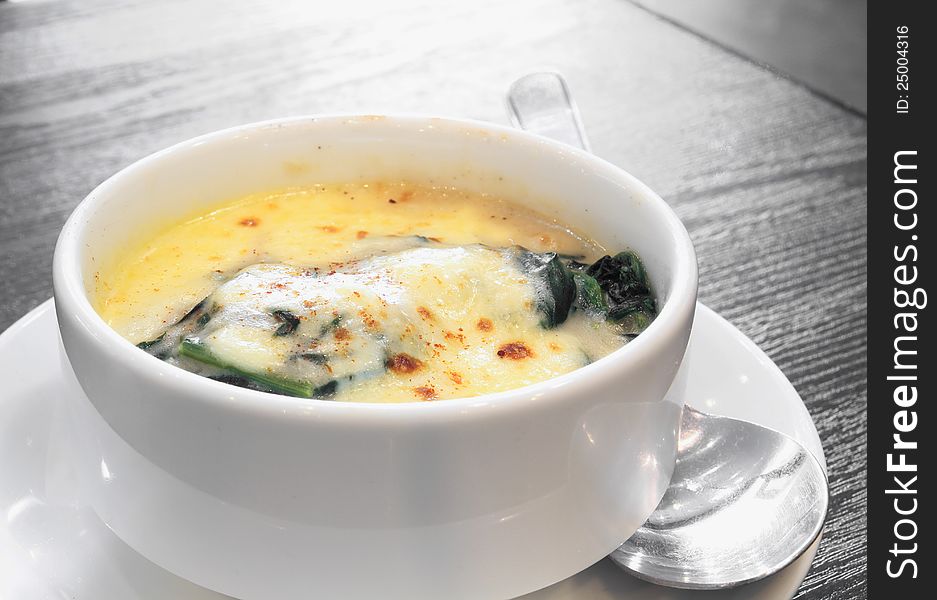 Delicious braked spinach gratin in white bowl