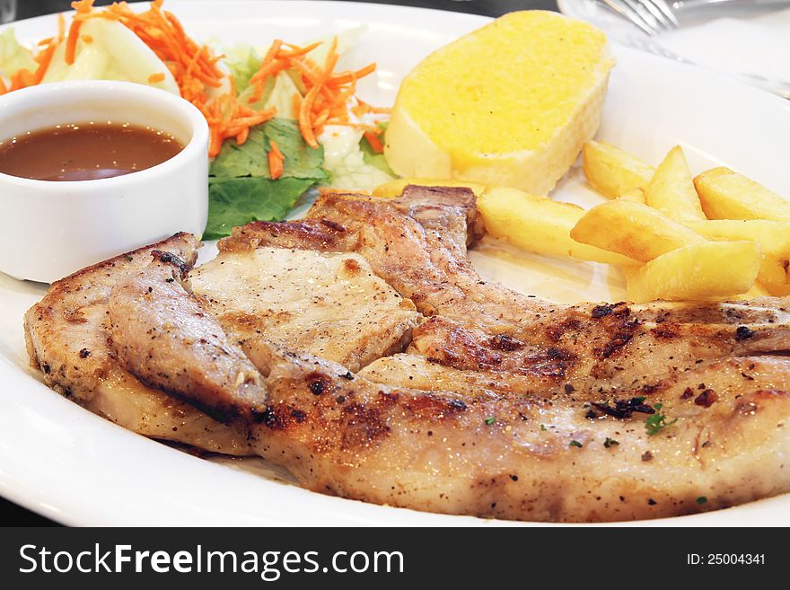 Delicious grilled pork chop in white dish