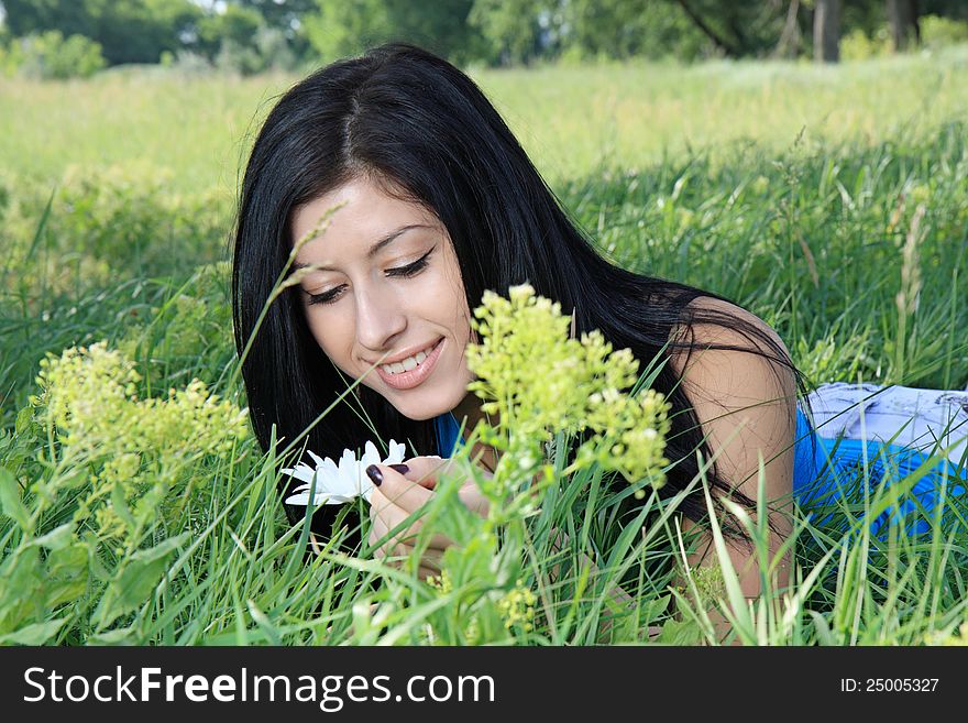 A beautiful young woman lying on grass