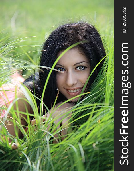 A beautiful young woman lying on grass