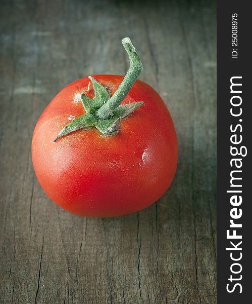 Fresh tomato on old wooden table