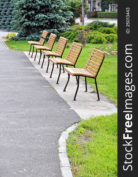 Bench on alley in a park near forest. Bench on alley in a park near forest