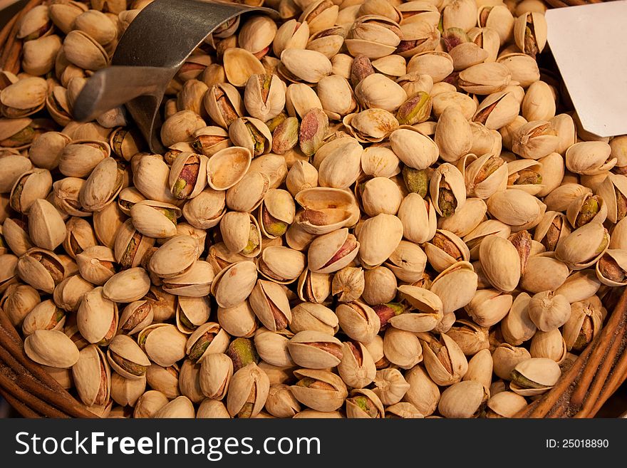 Many pistachios lie in a wattled basket in the market. Many pistachios lie in a wattled basket in the market.