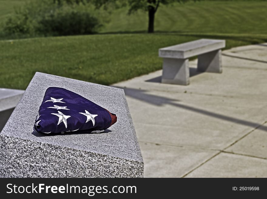 Folded American flag on memorial stone. Folded American flag on memorial stone