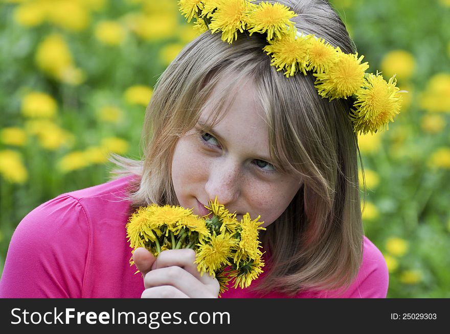 Happy girl in the field of dandelions