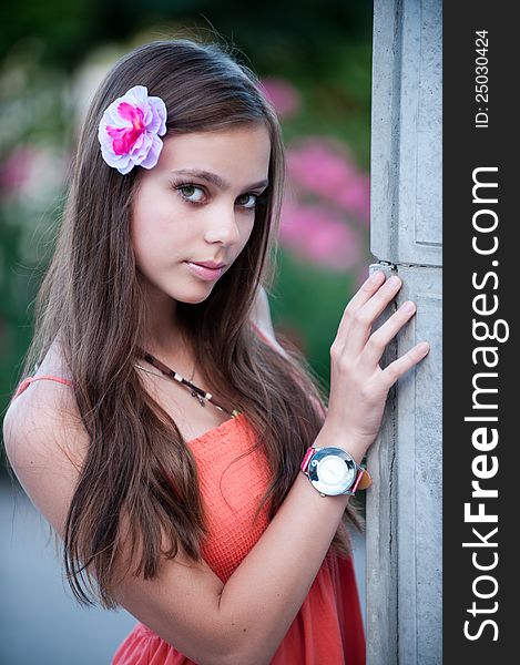 Portrait of beautiful fresh teenager girl with expressive look posing on a background of flowerbeds. Portrait of beautiful fresh teenager girl with expressive look posing on a background of flowerbeds