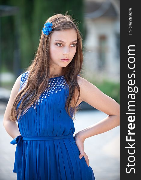 Portrait of beautiful fresh teenager girl with expressive look posing on a background of flowerbeds. Portrait of beautiful fresh teenager girl with expressive look posing on a background of flowerbeds