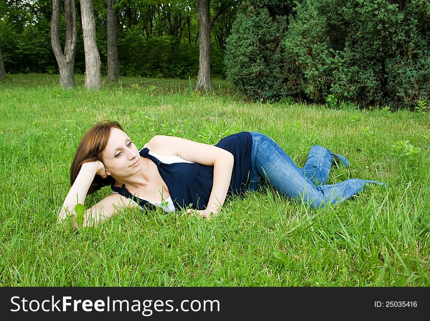 Beautiful girl lying on the grass enjoying the peace