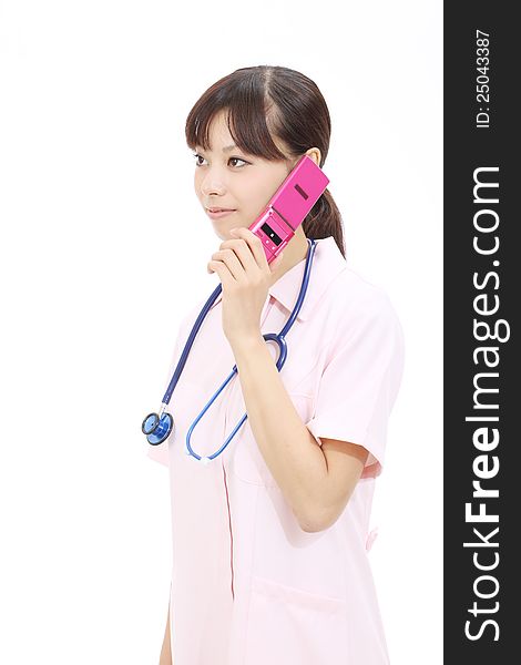 Young asian female nurse calling by cellular phone