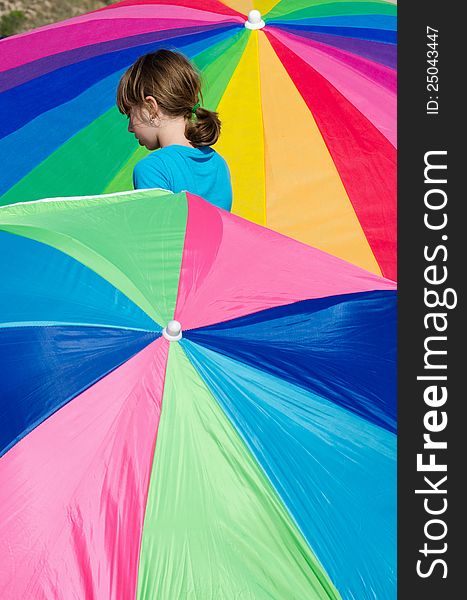 Little girl looks like she is trapped between rainbows of colorful umbrellas. Little girl looks like she is trapped between rainbows of colorful umbrellas