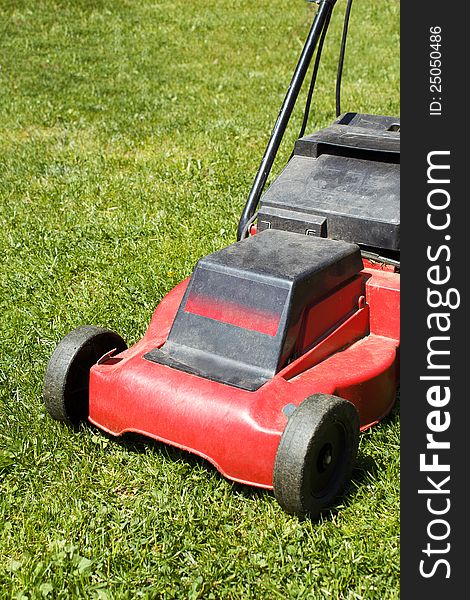 Lawnmower on green grass in sunny day