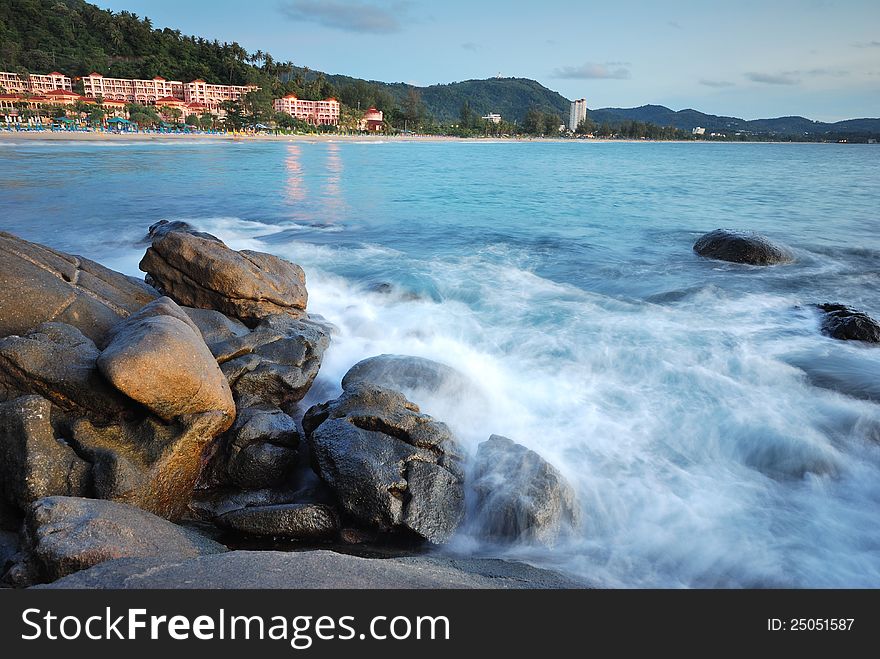 The rocky beach, surf, beautiful hotel in the background. The rocky beach, surf, beautiful hotel in the background.