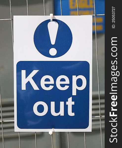 A keep out sign on a fence