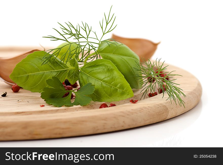 Basil, dill and parsley on wooden plate