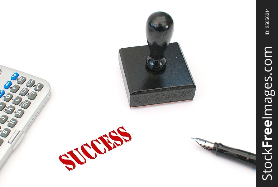 Ink print of the word success next to a stamp and calculator. Ink print of the word success next to a stamp and calculator