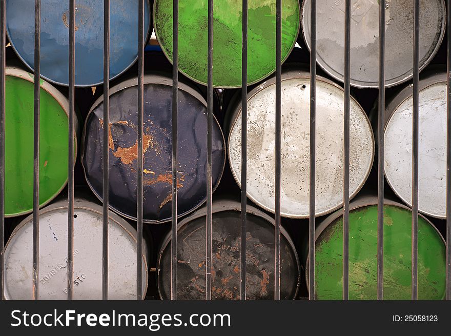 Multicolored Industrial Drums Behind Fence. Multicolored Industrial Drums Behind Fence