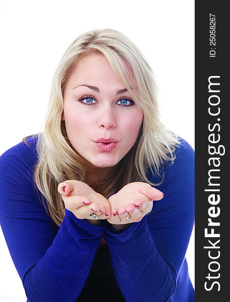 Beautiful blonde woman in blue blowing air over her cupped hands isolated on white. Beautiful blonde woman in blue blowing air over her cupped hands isolated on white.