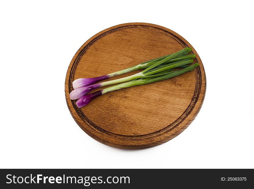 Spring red onions on a wooden mat