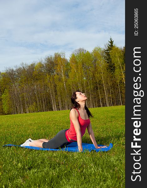 Yoga in the park. Cobra. Outdoor sport theme shot