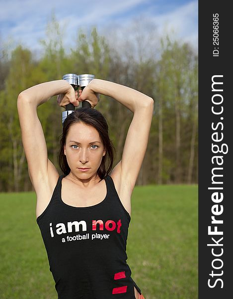 Woman working with dumbbell, sport theme shot