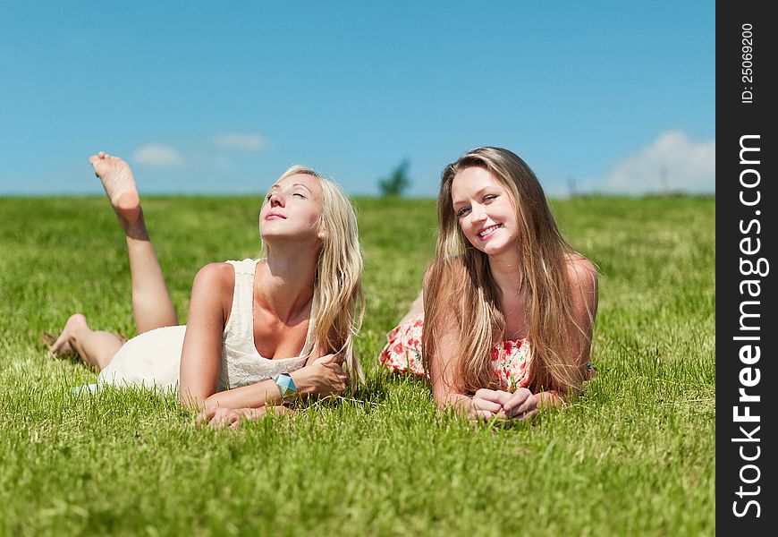 Two girlfriends on a grass field. Two girlfriends on a grass field