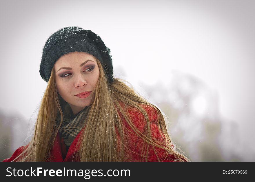 Happy girl with cap and gloves playing with snow