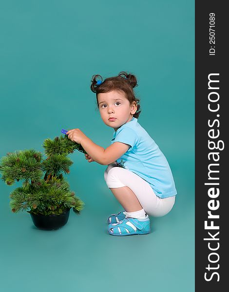 Girl Sitting Next To A Decorative Pine