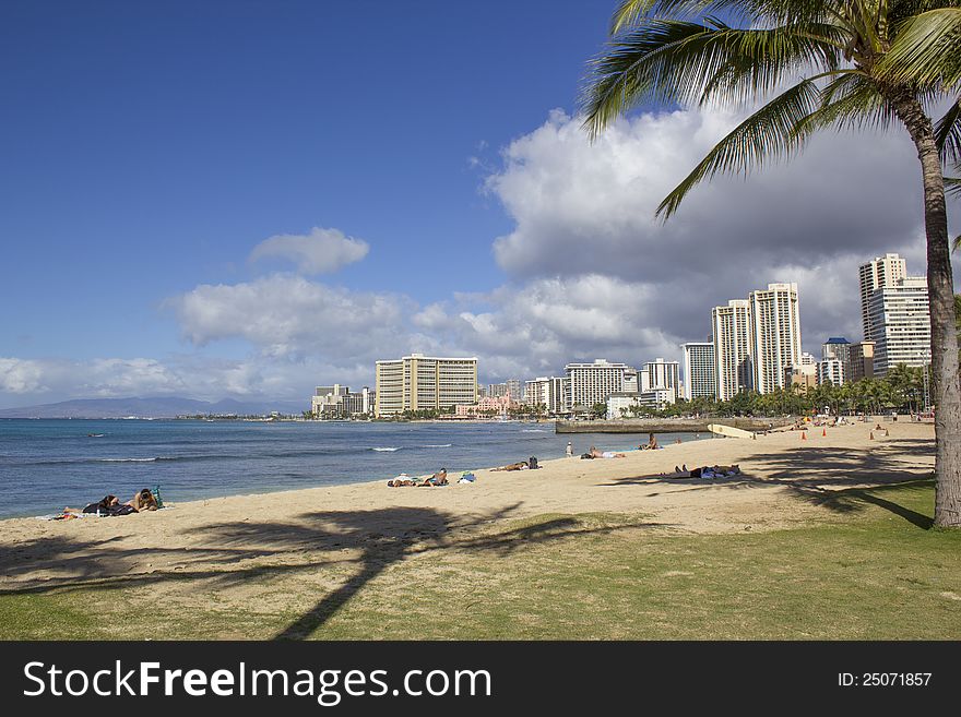 Waikiki Skyline and Beach with sunbathers.