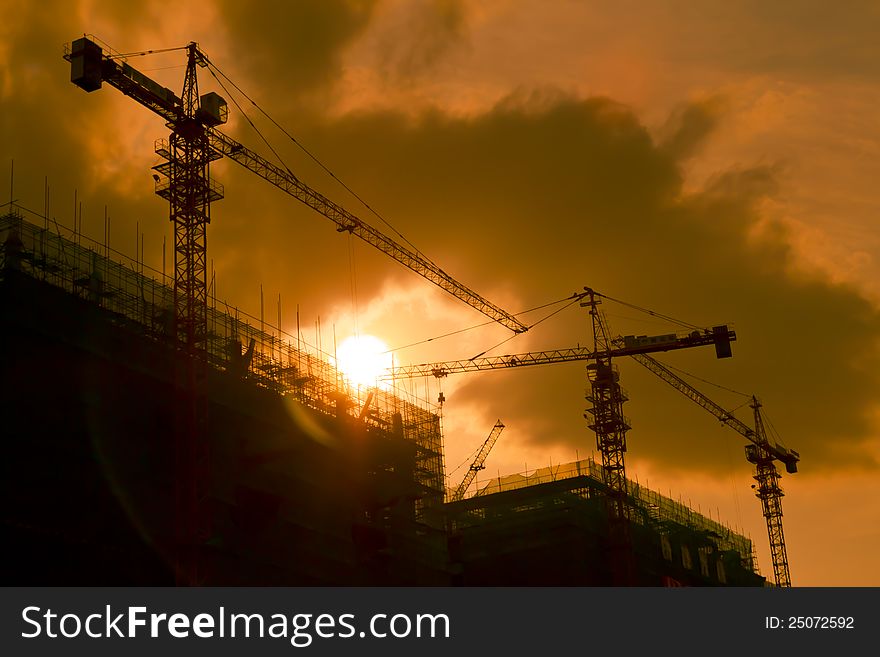 Shadowgraph construction site silhouetted at sunset