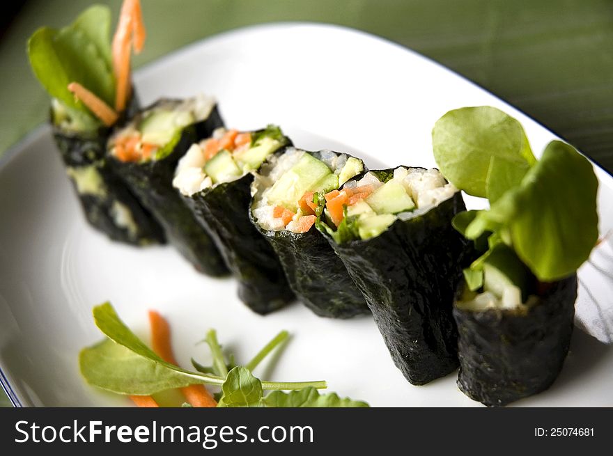 Close up vegetarian sushi roll on white plate. Close up vegetarian sushi roll on white plate