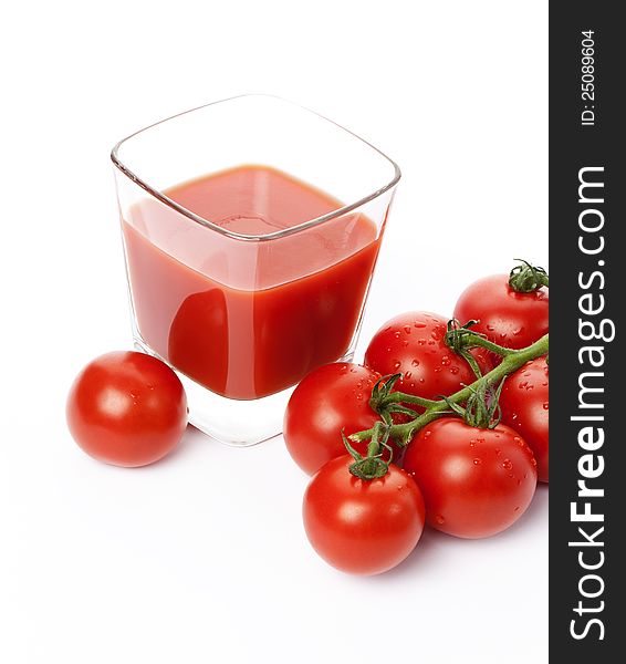 Fresh cherry tomatoes and a glass of tomato juice, isolated on white background