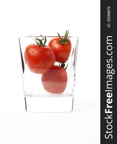 Fresh cherry tomatoes in a glass, isolated on white background