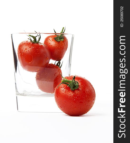 Fresh cherry tomatoes in a glass, isolated on white background