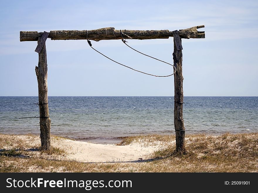 View of the beach behind the arch of wooden logs. View of the beach behind the arch of wooden logs