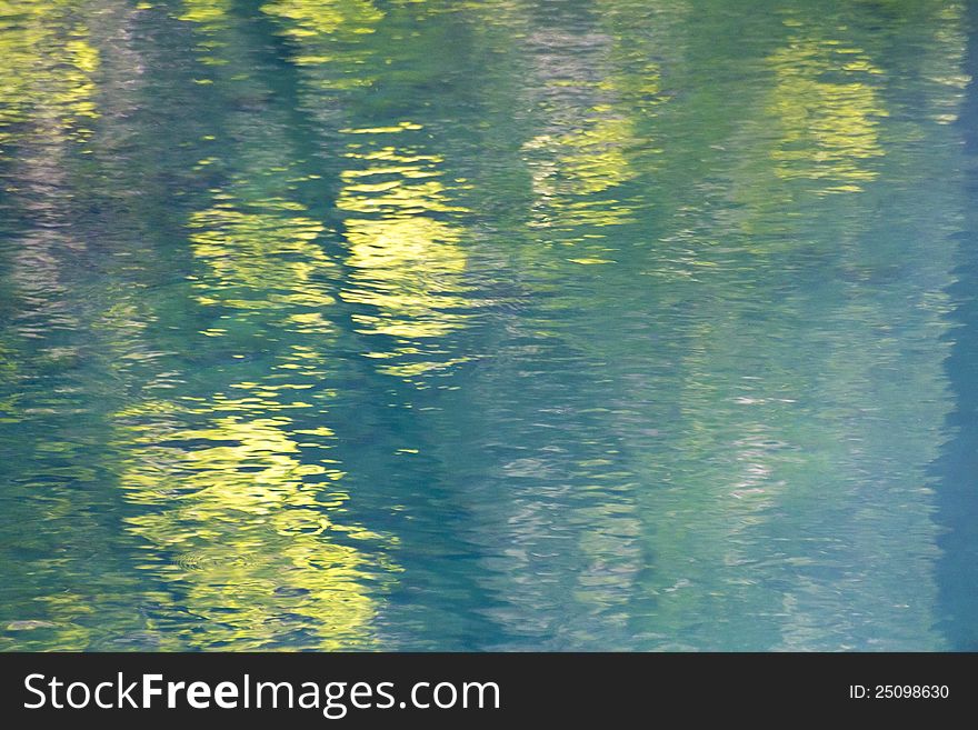 Reflections of trees in a smal blue lake - abstract background. Reflections of trees in a smal blue lake - abstract background