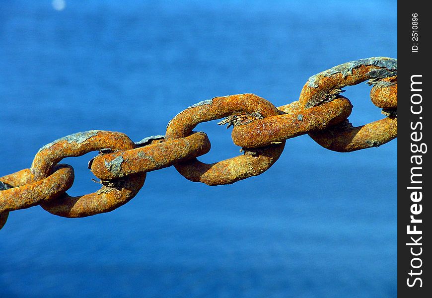 Macro view of a few rusty metal chain ring in high tension