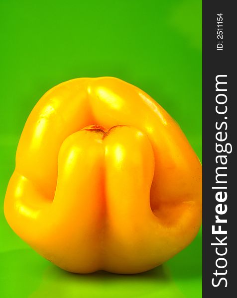 Yellow salad pepper on a green background