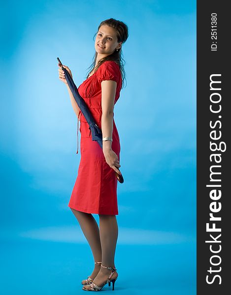 The girl in a red dress on a dark blue background with a umbrella. The girl in a red dress on a dark blue background with a umbrella